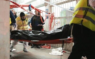 A body is removed from the site where a terrorist opened fire in Bnei Brak, Israel, March 29, 2022. (AP Photo/Oded Balilty)