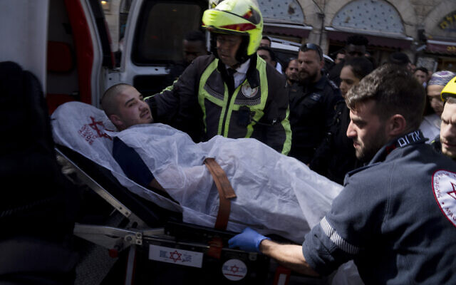 An injured man is loaded into an ambulance after an altercation in the Mahane Yehuda market in Jerusalem during which police shot two men, injuring them, March 30, 2022. (Maya Alleruzzo/AP) An injured man is loaded into an ambulance after an altercation in the Mahane Yehuda market in Jerusalem during which police shot two men, injuring them, March 30, 2022. (Maya Alleruzzo/AP)
