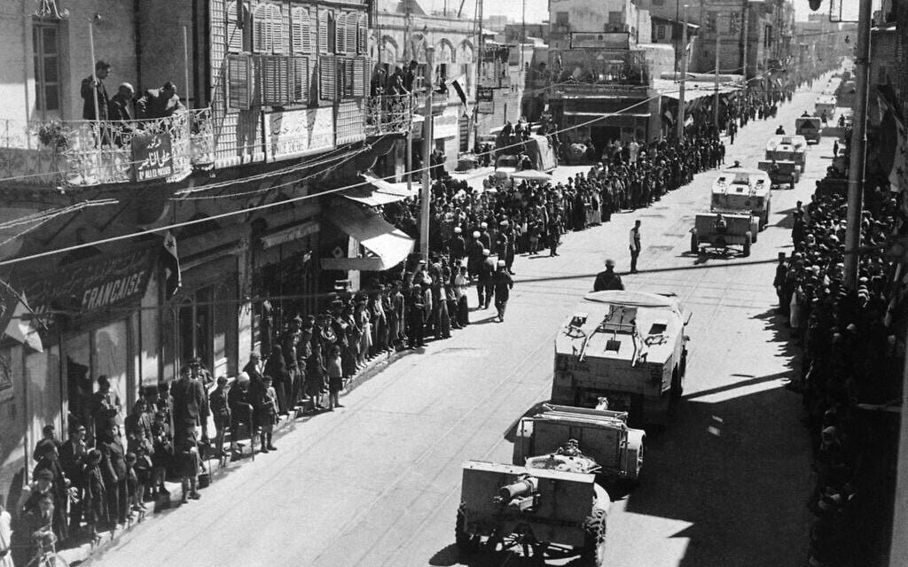 Crowds watch a New Zealand field regiment taking part in a ceremonial parade through the streets of Aleppo, Syria, on June 3, 1942. (AP Photo)