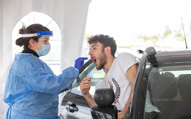 A technician collects a nasal swab sample for COVID-19 at the coronavirus lab, at the Ben Gurion International Airport on March 2, 2022. (Yossi Aloni/Flash90) A technician collects a nasal swab sample for COVID-19 at the coronavirus lab, at the Ben Gurion International Airport on March 2, 2022. (Yossi Aloni/Flash90)