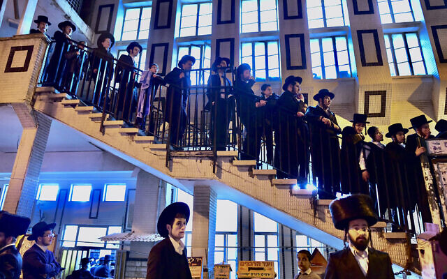 People gather outside the home of Rabbi Chaim Kanievsky who passed away, in the city of Bnei Brak, on March 19, 2022. (Avshalom Sassoni/ Flash90)