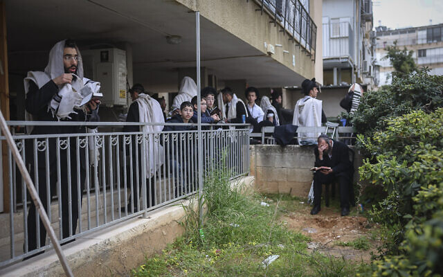 Men pray near the home of Rabbi Chaim Kanievsky on March 20, 2022 (Yonatan Sindel/ Flash90)
