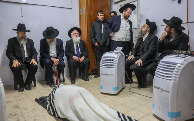Family and relatives pray as they gather around the body of Rabbi Chaim Kanievsky, Bnei Brak, March 20, 2022 (Yonatan Sindel/ Flash90)
