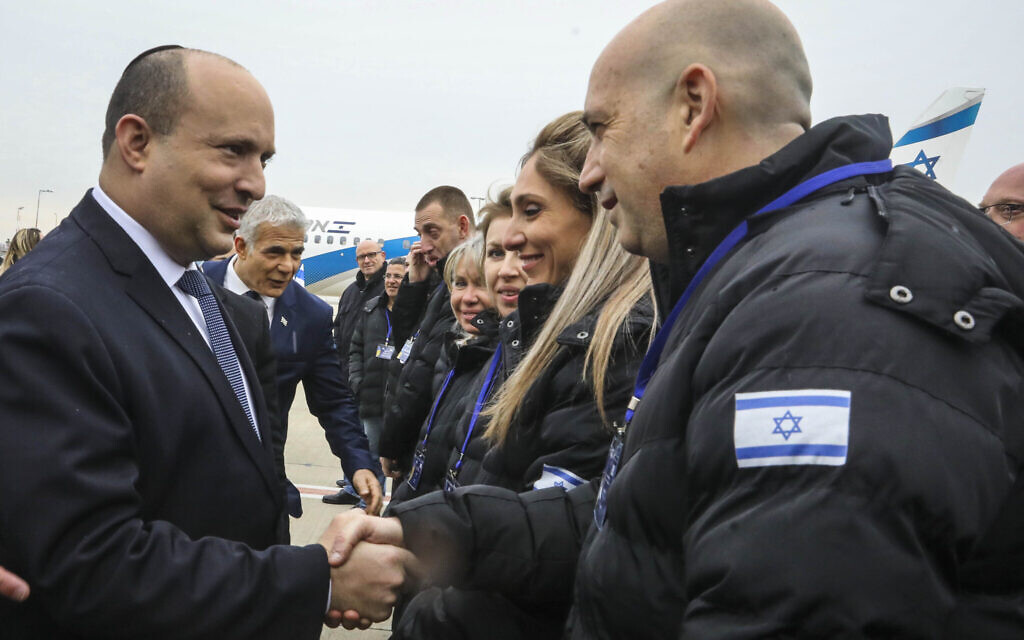 Prime Minister Naftali Bennett, left, speaks to members of the Israeli aid delegation for the establishment of a field hospital in Ukraine on March 21, 2022 at Ben Gurion airport near Tel Aviv. (Marc Israel Sellem/POOL)