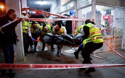 Members of the Zaka emergency organization remove a body from the scene of a terrorist attack in Bnei Brak, March 29, 2022. (Avshalom Sassoni/Flash90)