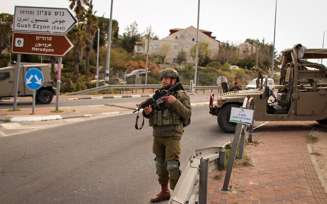 Illustrative: Israeli soldiers stand guard at the entrance to the Efrat settlement in the central West Bank on March 29, 2022. (Gershon Elinson/Flash90) Illustrative: Israeli soldiers stand guard at the entrance to the Efrat settlement in the central West Bank on March 29, 2022. (Gershon Elinson/Flash90)