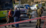 Israeli soldiers, police, and medics are seen at the scene of a stabbing attack near the Neve Daniel junction in the West Bank, March 31, 2022. (Yonatan Sindel/FLASH90)
