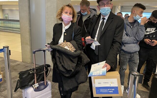 El Al passengers boarding a plane to Bucharest with packages for Ukrainian refugees at Ben Gurion Airport on March 14, 2022. (Sue Surkes/Times of Israel) El Al passengers boarding a plane to Bucharest with packages for Ukrainian refugees at Ben Gurion Airport on March 14, 2022. (Sue Surkes/Times of Israel)