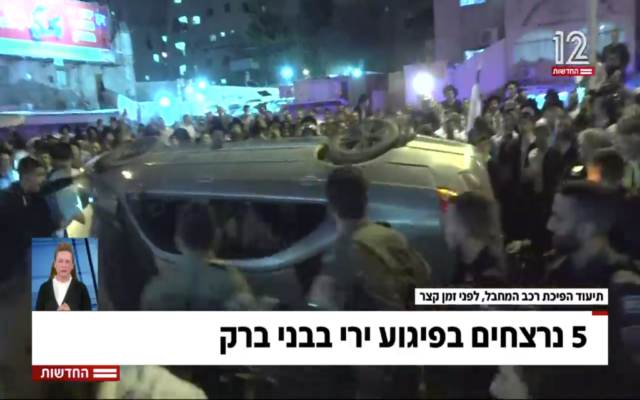 A Bnei Brak crowd takes out their anger on a vehicle suspected of having belonged to the shooter in a terror attack, on March 29, 2022. (Screen capture/Channel 12) A Bnei Brak crowd takes out their anger on a vehicle suspected of having belonged to the shooter in a terror attack, on March 29, 2022. (Screen capture/Channel 12)