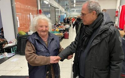 Diaspora Affairs Minister Dr. Nachman Shai (right) greets Rita Parjanskaya, aged 84, in a refugee reception area in Korczowa, Poland, just across the Ukrainian-Polish border, March 8, 2022. (Office of Diaspora Affairs Minister Dr. Nachman Shai)