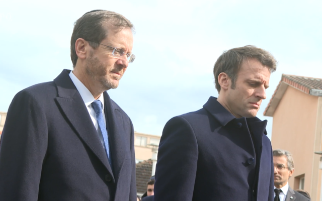 President Isaac Herzog and French President Emmanuel Macron stand for a minute’s silence at a ceremony marking the 10-year anniversary of a shooting attack that left three soldiers and four Jewish civilians dead at the Ohr Torah Jewish school in Toulouse, France, March 20, 2022. (Screengrab/ Omer Meron/ GPO)