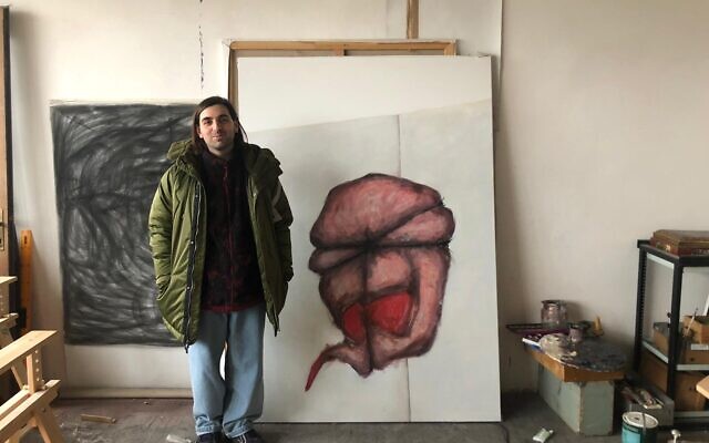 Vadim Panchenko in front of one of his paintings at Zavod, on March 8, 2022. (Lazar Berman/The Times of Israel)