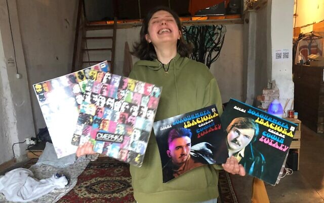 Victoria, a Ukrainian photographer, holds her work at Zavod, on March 8, 2022. (Lazar Berman/The Times of Israel)