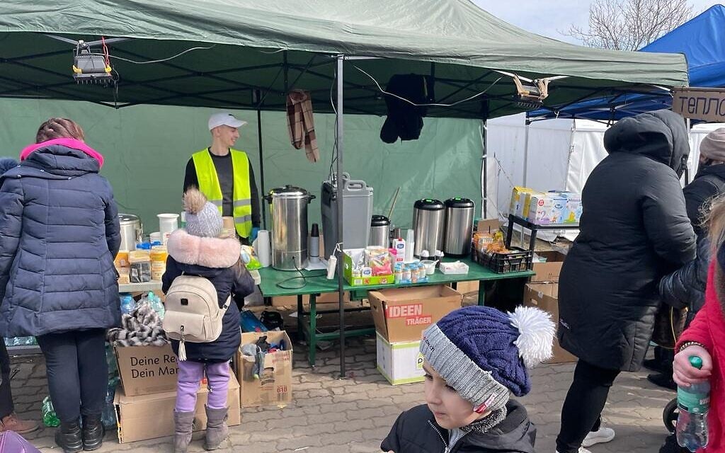 Volunteers and Ukrainian refugees at the border crossing between Poland and Ukraine, at Medyka, Poland, March 15, 2022. (Carrie Keller-Lynn/The Times of Israel)