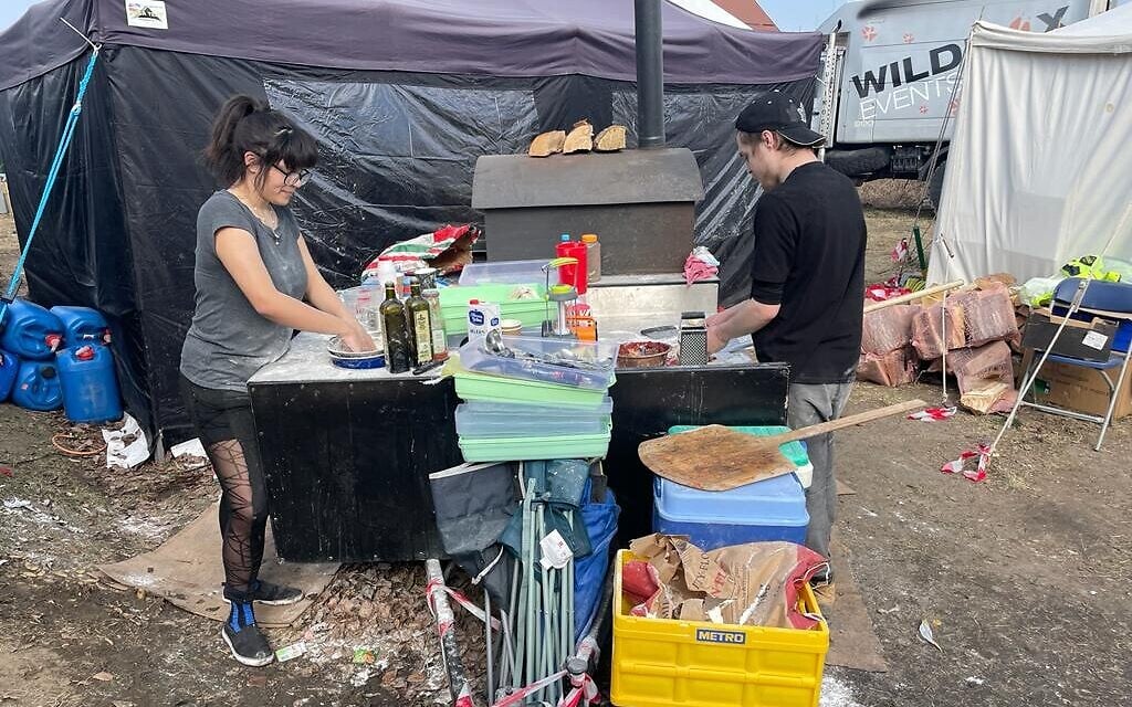 Scottish volunteers preparing wood-fired stove pizza at the border crossing between Poland and Ukraine, at Medyka, Poland, March 15, 2022. (Carrie Keller-Lynn/The Times of Israel)