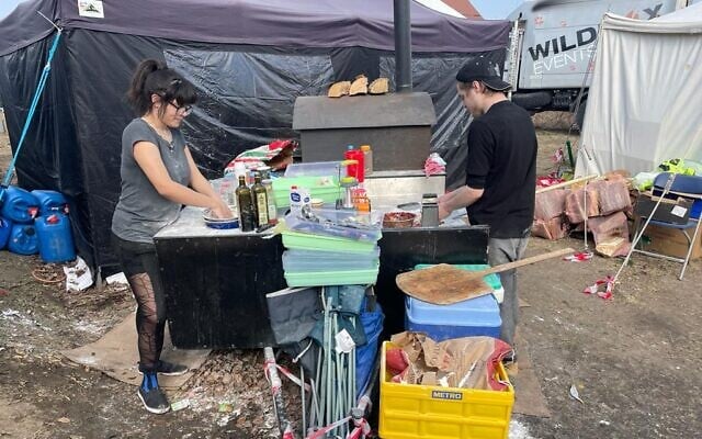 Scottish volunteers preparing wood-fired stove pizza at the border crossing between Poland and Ukraine, at Medyka, Poland, March 15, 2022. (Carrie Keller-Lynn/The Times of Israel)