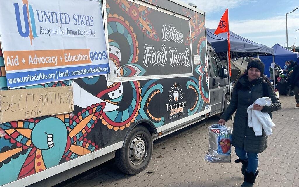 Volunteer food trucks and a Ukrainian refugee at the border crossing between Poland and Ukraine, at Medyka, Poland, March 15, 2022. (Carrie Keller-Lynn/The Times of Israel)