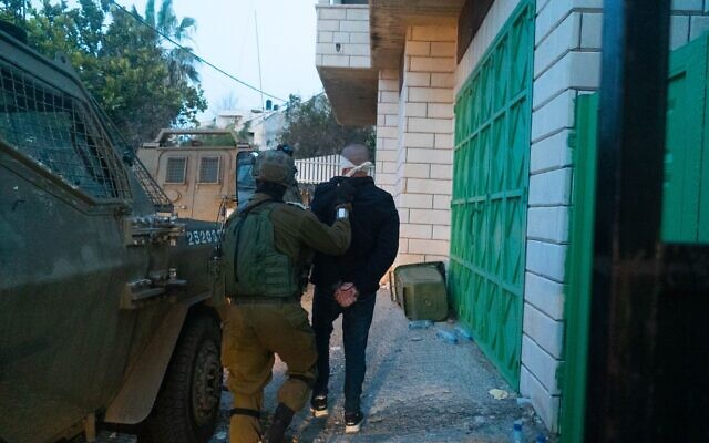 Soldiers detain a suspect in the West Bank town of Ya’bad near Jenin, following a deadly terror attack in Bnei Brak, March 30, 2022. (Israel Defense Forces) Soldiers detain a suspect in the West Bank town of Ya’bad near Jenin, following a deadly terror attack in Bnei Brak, March 30, 2022. (Israel Defense Forces)