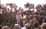 Leonard Cohen, center, performs with Israeli singer Matti Caspi, on guitar, for Israeli troops in the Sinai in 1973. Ariel Sharon is to the left of Cohen, with arms crossed. (Yakovi Doron)
