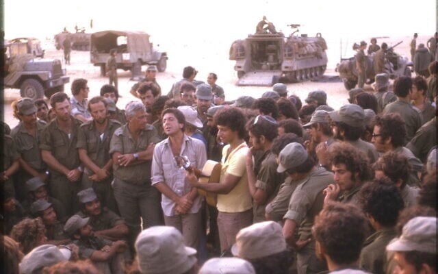 Leonard Cohen, center, performs with Israeli singer Matti Caspi, on guitar, for Israeli troops in the Sinai in 1973. Ariel Sharon is to the left of Cohen, with arms crossed. (Yakovi Doron) Leonard Cohen, center, performs with Israeli singer Matti Caspi, on guitar, for Israeli troops in the Sinai in 1973. Ariel Sharon is to the left of Cohen, with arms crossed. (Yakovi Doron)