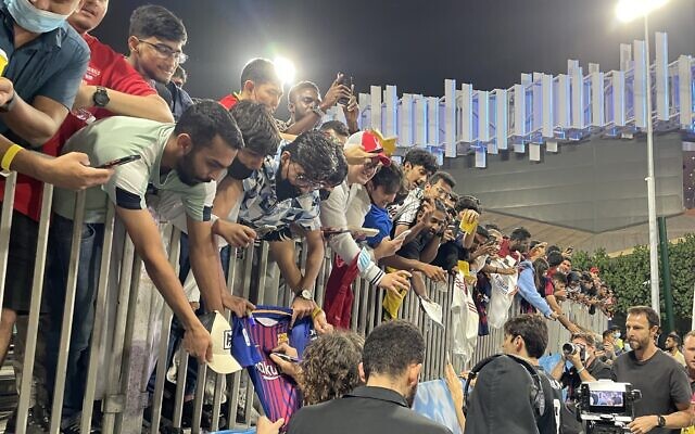 Fans strain for autographs from some of the soccer legends that played at a festive soccer match between an Abraham Accords team made up of players from Israel, the UAE, Bahrain and Morocco and one comprising world soccer stars, Dubai, March 29, 2022. (Sue Surkes/Times of Israel) Fans strain for autographs from some of the soccer legends that played at a festive soccer match between an Abraham Accords team made up of players from Israel, the UAE, Bahrain and Morocco and one comprising world soccer stars, Dubai, March 29, 2022. (Sue Surkes/Times of Israel)