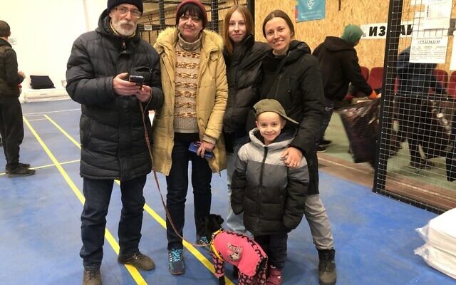 Marcel, dressed in pink, with his owners Ira and Yehor  Brodsky (left) from Sievierodonetsk in the eastern Luhansk region of Ukraine, pictured at the Joint Distribution Committee's hub in Chișinău, Moldova, March 17, 2022. To their right is a family from Kharkiv. (Sue Surkes/Times of Israel).
