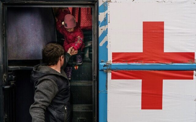 A child is helped off a bus at the registration center in Zaporizhzhia, where the International Committee of the Red Cross said it had a team of three cars and nine staff waiting to head out towards the besieged city of Mariupol from Zaporizhzhia, more than 200 kilometres away on April 1, 2022. (Emre Caylak / AFP) A child is helped off a bus at the registration center in Zaporizhzhia, where the International Committee of the Red Cross said it had a team of three cars and nine staff waiting to head out towards the besieged city of Mariupol from Zaporizhzhia, more than 200 kilometres away on April 1, 2022. (Emre Caylak / AFP)