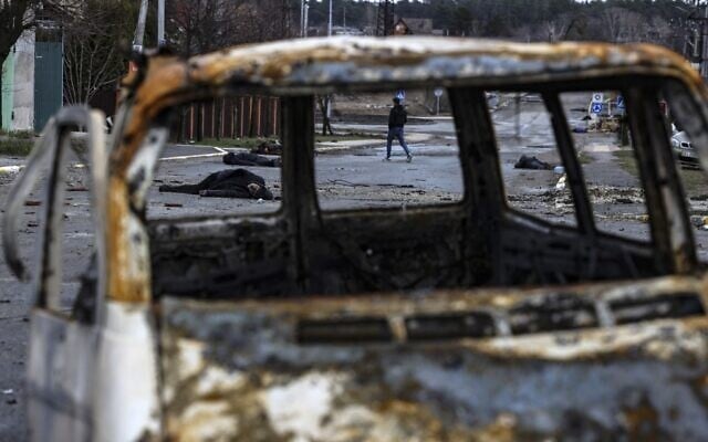 A man walks on a street with several dead bodies on the ground a street in Bucha, northwest of Kyiv, as Ukraine says Russian forces are making a 'rapid retreat' from northern areas around Kyiv and the city of Chernigiv, on April 2, 2022 (RONALDO SCHEMIDT / AFP) A man walks on a street with several dead bodies on the ground a street in Bucha, northwest of Kyiv, as Ukraine says Russian forces are making a 'rapid retreat' from northern areas around Kyiv and the city of Chernigiv, on April 2, 2022 (RONALDO SCHEMIDT / AFP)