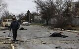 A man walks on a street with several dead bodies on the ground in Bucha, northwest of Kyiv, Ukraine, on April 2, 2022. (RONALDO SCHEMIDT / AFP)