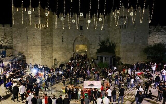 Palestinians gather outside the Damascus gate in Jerusalem's Old City on April 2, 2022, on the first day of the holy Muslim month of Ramadan. (Menahem Kahana/AFP) Palestinians gather outside the Damascus gate in Jerusalem's Old City on April 2, 2022, on the first day of the holy Muslim month of Ramadan. (Menahem Kahana/AFP)