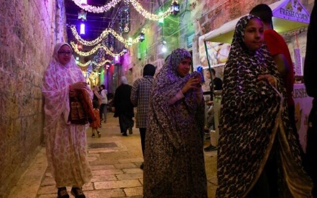 Palestinians walk down a street in Jerusalem's Old City on April 2, 2022, on the first day of the holy Muslim month of Ramadan. (Photo by Menahem KAHANA / AFP) Palestinians walk down a street in Jerusalem's Old City on April 2, 2022, on the first day of the holy Muslim month of Ramadan. (Photo by Menahem KAHANA / AFP)