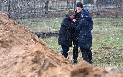 People react as they gather close to a mass grave in the town of Bucha, just northwest of the Ukrainian capital Kyiv on April 3, 2022. (Sergei SUPINSKY / AFP) People react as they gather close to a mass grave in the town of Bucha, just northwest of the Ukrainian capital Kyiv on April 3, 2022. (Sergei SUPINSKY / AFP)