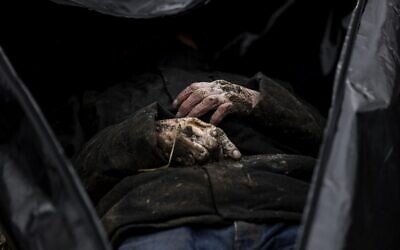 A body is partially pictured as body bags are gathered in a cemetery of Bucha, north of Kyiv, on April 6, 2022 for identification, after hundreds of civilians were found dead in areas from which Russian troops have withdrawn around Ukraine's capital, including the town of Bucha (RONALDO SCHEMIDT / AFP)