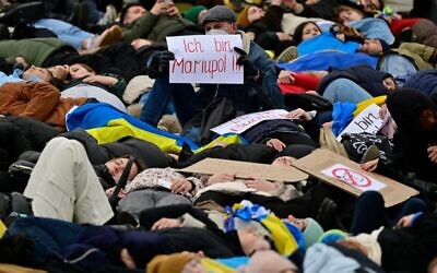A man holds up a placard which reads "I am Mariupol!!" as pro-Ukrainian activists stage a "Die-in" during a protest under the slogan "Stop promising, start acting!" to call for an immediate embargo on oil, gas and coal imports from Russia in front of the Bundestag (lower house of parliament) in Berlin, April 6, 2022. (John MACDOUGALL / AFP) A man holds up a placard which reads "I am Mariupol!!" as pro-Ukrainian activists stage a "Die-in" during a protest under the slogan "Stop promising, start acting!" to call for an immediate embargo on oil, gas and coal imports from Russia in front of the Bundestag (lower house of parliament) in Berlin, April 6, 2022. (John MACDOUGALL / AFP)