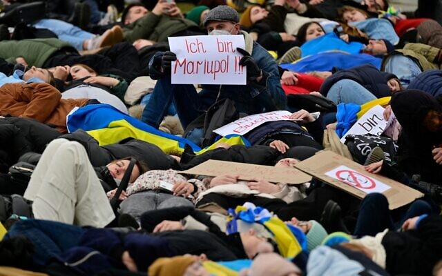A man holds up a placard which reads "I am Mariupol!!" as pro-Ukrainian activists stage a "Die-in" during a protest under the slogan "Stop promising, start acting!" to call for an immediate embargo on oil, gas and coal imports from Russia in front of the Bundestag (lower house of parliament) in Berlin, April 6, 2022. (John MACDOUGALL / AFP) A man holds up a placard which reads "I am Mariupol!!" as pro-Ukrainian activists stage a "Die-in" during a protest under the slogan "Stop promising, start acting!" to call for an immediate embargo on oil, gas and coal imports from Russia in front of the Bundestag (lower house of parliament) in Berlin, April 6, 2022. (John MACDOUGALL / AFP)