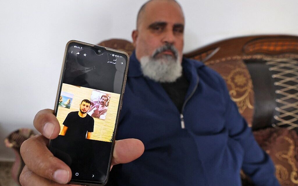A Palestinian man displays a picture of his nephew Raad Hazem, 28, a Palestinian terrorist who killed three Israelis and wounded several others in Tel Aviv the previous night, on April 8, 2022 in the West Bank city of Jenin. (JAAFAR ASHTIYEH / AFP)