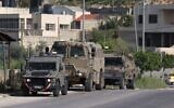 IDF vehicles in the Nur Shams Palestinian refugee camp on April 10, 2022, during a raid looking for terror suspects. (JAAFAR ASHTIYEH / AFP)