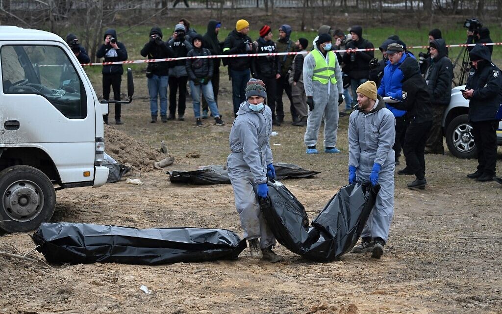 Journalists gather as bodies are exhumed and removed from a mass grave in the grounds of the St. Andrew and Pyervozvannoho All Saints church in the Ukrainian town of Bucha, northwest of Kyiv on April 13, 2022. (Sergei SUPINSKY / AFP) Journalists gather as bodies are exhumed and removed from a mass grave in the grounds of the St. Andrew and Pyervozvannoho All Saints church in the Ukrainian town of Bucha, northwest of Kyiv on April 13, 2022. (Sergei SUPINSKY / AFP)