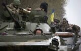 Ukrainian soldiers stand on their armored personnel carrier, not far from the front-line with Russian troops, in Izium district, Kharkiv region, on April 18, 2022, during the Russian invasion of Ukraine. (Anatolii Stepanov/AFP)