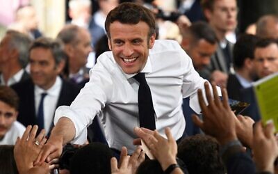 French President and centrist La Republique en Marche (LREM) party candidate for re-election Emmanuel Macron shakes hands with supporters as he holds a rally on the last day of campaigning, in Figeac, southern France, on April 22, 2022 (Lionel BONAVENTURE / AFP)