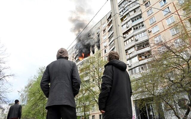 People watch flames coming out of an appartement in a residential building of the northern outskirts of Kharkiv following shelling, on April 22, 2022. (Sergey Bobok/AFP) People watch flames coming out of an appartement in a residential building of the northern outskirts of Kharkiv following shelling, on April 22, 2022. (Sergey Bobok/AFP)