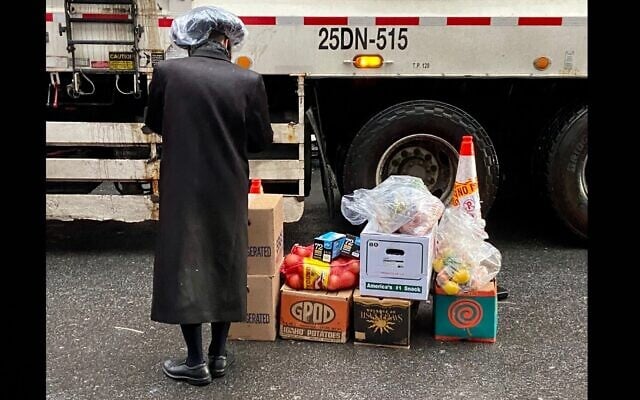 A Satmar Orthodox man volunteers to deliver free food provided by Met Council at a distribution center at the Brooklyn Navy Yard run by the United Jewish Organizations of Williamsburg, on April 10, 2022. (Jacob Henry/JTA)