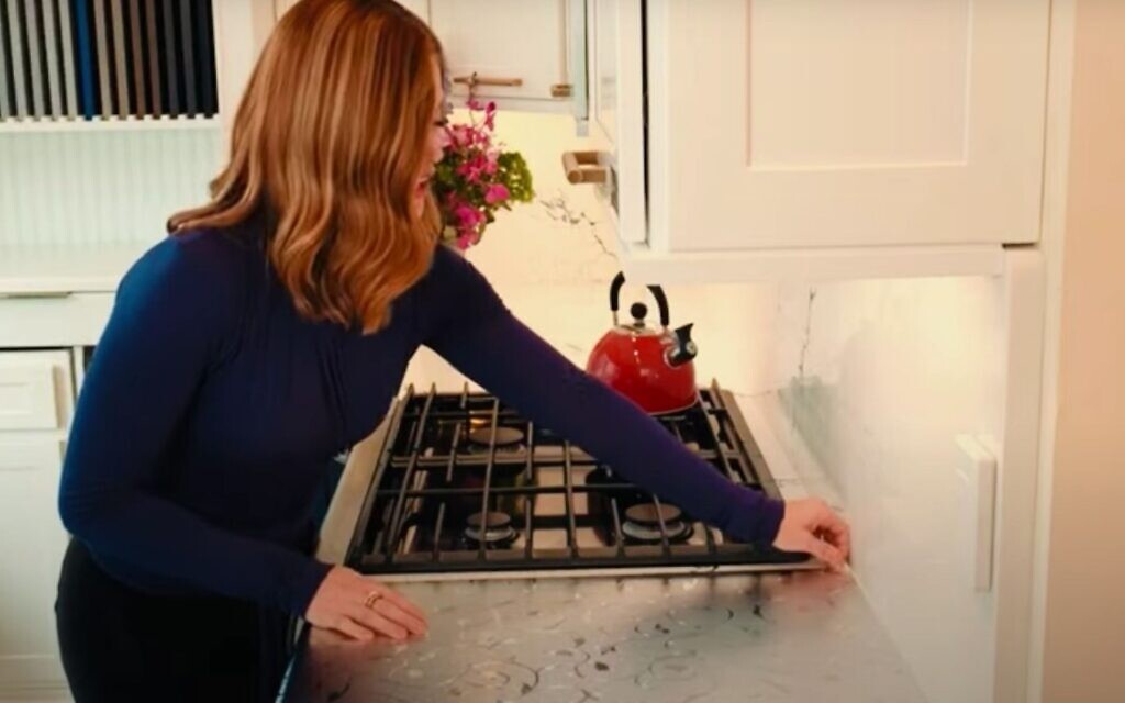 In a promotional video for Kosher Dekal, a woman takes off the product from a kitchen counter. (YouTube/ via JTA) In a promotional video for Kosher Dekal, a woman takes off the product from a kitchen counter. (YouTube/ via JTA)