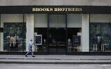 Pedestrians wearing protective masks walk past a Brooks Brothers store in New York, on July 8, 2020. (Frank Franklin II/AP)