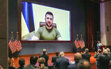 Members of Congress give Ukraine President Volodymyr Zelensky a standing ovation before he speaks in a virtual address to Congress in the US Capitol Visitors Center Congressional Auditorium in Washington, DC, on Wednesday, March 16, 2022. (Sarahbeth Maney/The New York Times via AP, Pool, File)