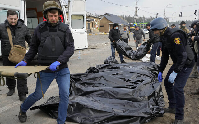 Volunteers and soldiers collect bodies of civilians killed by the Russian forces at the destroyed bridge in Irpin close to Kyiv, Ukraine, Thursday, March 31, 2022. The more than month-old war has killed thousands and driven more than 10 million Ukrainians from their homes including almost 4 million from their country. (AP Photo/Efrem Lukatsky)