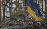 Ukrainian servicemen ride on an armored transporter driving through a Russian position overran by Ukrainian forces outside Kyiv, Ukraine, on March 31, 2022. (AP Photo/Vadim Ghirda)