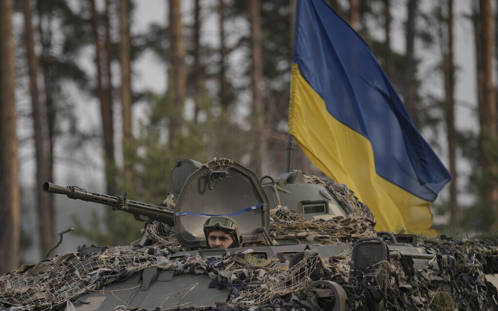 Ukrainian servicemen ride on an armored transporter driving through a Russian position overran by Ukrainian forces outside Kyiv, Ukraine, Thursday, March 31, 2022. Heavy fighting raged on the outskirts of Kyiv and other zones Thursday amid indications the Kremlin is using talk of de-escalation as cover while regrouping and resupplying its forces and redeploying them for a stepped-up offensive in eastern Ukraine.(AP Photo/Vadim Ghirda) Ukrainian servicemen ride on an armored transporter driving through a Russian position overran by Ukrainian forces outside Kyiv, Ukraine, Thursday, March 31, 2022. Heavy fighting raged on the outskirts of Kyiv and other zones Thursday amid indications the Kremlin is using talk of de-escalation as cover while regrouping and resupplying its forces and redeploying them for a stepped-up offensive in eastern Ukraine.(AP Photo/Vadim Ghirda)