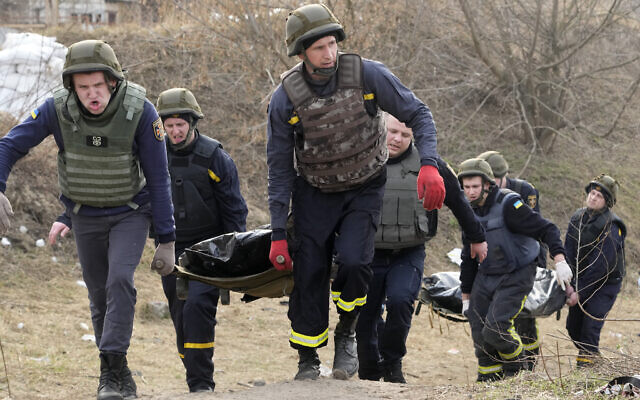 Ukrainian emergency services carry bodies of civilians killed by the Russian troops over the destroyed bridge in Irpin close to Kyiv, Ukraine, March 31, 2022. (AP Photo/Efrem Lukatsky) Ukrainian emergency services carry bodies of civilians killed by the Russian troops over the destroyed bridge in Irpin close to Kyiv, Ukraine, March 31, 2022. (AP Photo/Efrem Lukatsky)