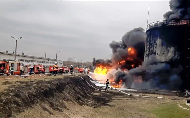 In this handout photo released by Russian Emergency Ministry Press Service on Friday, April 1, 2022, firefighters work at the site of fire at an oil depot in Belgorod region, Russia. The governor of the Russian border region of Belgorod accused Ukraine of flying helicopter gunships into Russian territory and striking an oil depot Friday morning.  (Russian Emergency Ministry Press Service via AP)